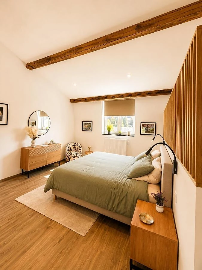 La chambre : lit vert sauge, commode et miroir rond